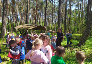 Dzieci i leśniczy w miejcu dokarmiania zwierząt w lesie